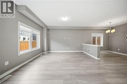 The property features an expansive open concept living area with light-toned flooring, neutral grey walls, and large windows - 