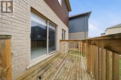 The property features a wooden deck with railing, accessible via a sliding glass door, and a brick exterior - 