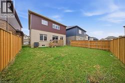 The property features a spacious rear yard with a well-maintained lawn, enclosed by a wooden privacy fence - 