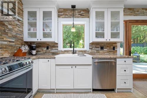 Kitchen view toward backyard with outdoor dining patio and pond - 58 Central Drive, Hamilton, ON 