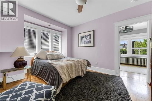 Hardwood flooring throughout featuring a window box with three casement windows, a ceiling fan, and a mini-split system - 110 Melrose Avenue S, Hamilton, ON 