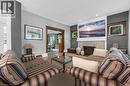 Living area featuring a stone-clad fireplace with a dark metal insert, flanked by two windows with wood trim - 110 Melrose Avenue S, Hamilton, ON 