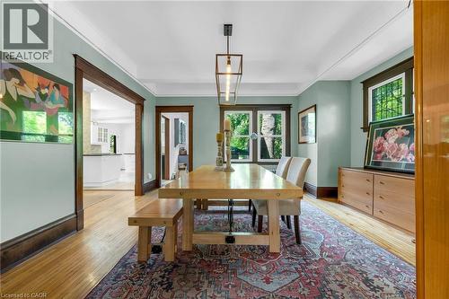 Dining area featuring hardwood flooring, a coffered ceiling, and dark wood trim - 110 Melrose Avenue S, Hamilton, ON 