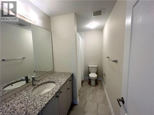 Bathroom featuring a spacious vanity with a granite countertop and an undermount sink - 66 Aviron Crescent, Welland, ON 