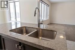 Details with light wood-type flooring, baseboards, light stone counters, and a sink - 