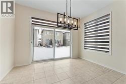 Empty room with baseboards, visible vents, a chandelier, and a wealth of natural light - 