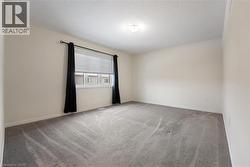Carpeted spare room featuring a textured ceiling and baseboards - 