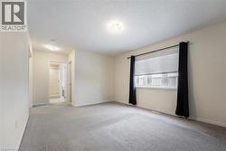 Carpeted empty room with baseboards and a textured ceiling - 