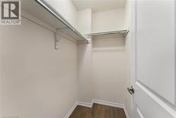 Walk in closet with dark wood-style floors - 