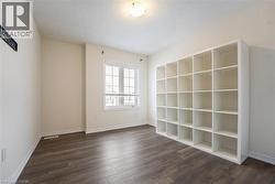 Unfurnished room with dark wood-style floors, a textured ceiling, and baseboards - 