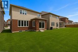 Expansive green lawn with a newly built home featuring brick and siding exterior - 