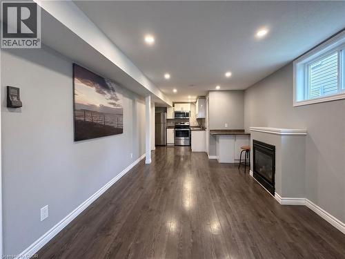 Open-concept living space featuring wood-finish flooring, recessed lighting, and a built-in fireplace with white trim - 304 Lemon Grass Crescent Unit# B, Kitchener, ON 