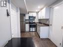 Kitchen featuring white cabinetry, stainless steel appliances, speckled countertops, and wood-finish flooring - 304 Lemon Grass Crescent Unit# B, Kitchener, ON 