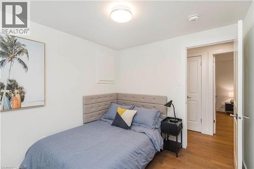 Compact room featuring hardwood-style flooring, white walls, and a contemporary flush-mount ceiling light - 39 Forestgate Drive, Hamilton, ON 