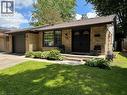 Brick exterior featuring a front entry with double doors, an attached garage, and a concrete walkway - 39 Forestgate Drive, Hamilton, ON 