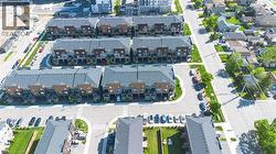 Residential development featuring rows of townhomes with dark shingle roofs, balconies, and individual parking spaces - 