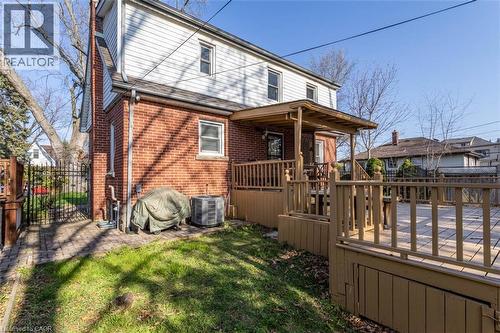 Rear exterior featuring a brick first story and white siding on the second story - 17 Thorndale Street N, Hamilton, ON 