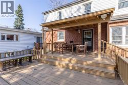 Multi-level wood deck featuring a covered porch area with a brick exterior - 