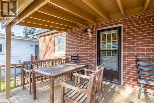 Covered rear porch featuring a wood-finish floor and exposed ceiling joists - 17 Thorndale Street N, Hamilton, ON 