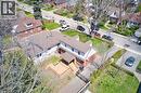 Two-story property featuring a multi-level deck, dark shingle roofing, and red brick lower exterior - 17 Thorndale Street N, Hamilton, ON 