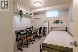 Room featuring tiled flooring, a built-in wall shelf, recessed window with blinds, and white painted walls - 