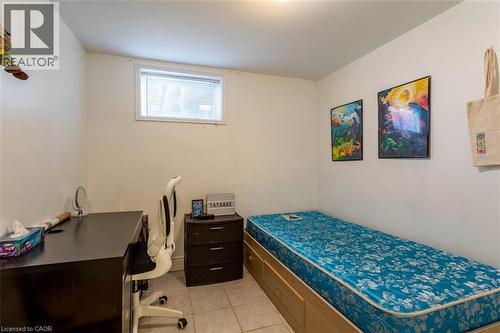 Room featuring tiled flooring, a window with blinds, and white painted walls - 17 Thorndale Street N, Hamilton, ON 