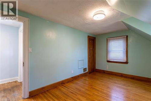 Room featuring wood-finish flooring, light blue walls, and a white ceiling - 17 Thorndale Street N, Hamilton, ON 