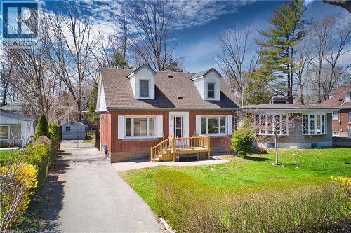Brick home with dormer windows, featuring a front lawn and paved driveway - 17 Thorndale Street N, Hamilton, ON 