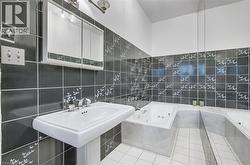 Pedestal sink with chrome fixtures, a medicine cabinet with integrated lighting, and a jetted tub - 