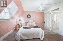 Attic bedroom featuring sloped ceilings, a dormer window, and patterned wallpaper - 