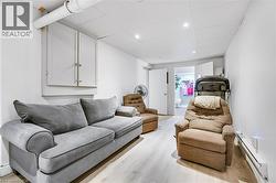 Finished space featuring light wood-finish flooring, white walls, and a drop ceiling with recessed lighting - 