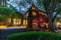 Exterior featuring a large spa, mature trees, and a brick facade with ivy - 