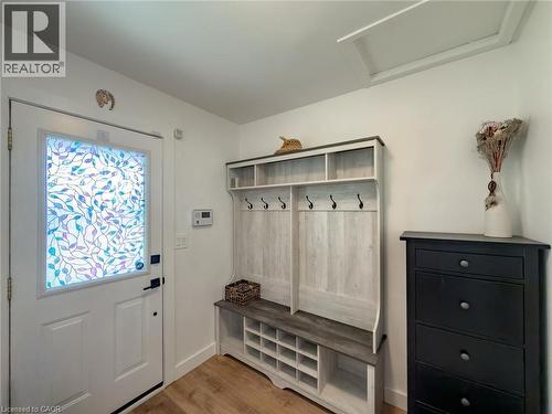 Entryway featuring a white door with decorative glass, wood-finish flooring, and a built-in coat and shoe storage unit - 1324 Bodley Road, Mississauga, ON 