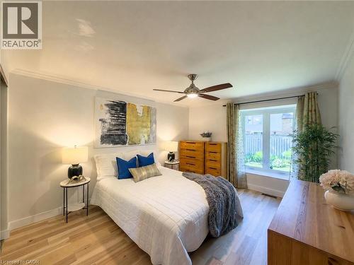 Bedroom featuring light wood-finish flooring, crown molding, and a ceiling fan with integrated lighting - 1324 Bodley Road, Mississauga, ON 