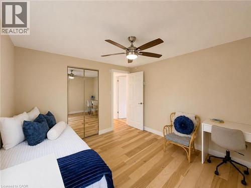 Room featuring wood-finish flooring, a ceiling fan with integrated lighting, and a mirrored closet - 1324 Bodley Road, Mississauga, ON 