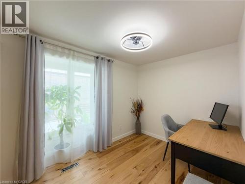 Bright interior space featuring wood-finish flooring, a contemporary ceiling light fixture, and a large window - 1324 Bodley Road, Mississauga, ON 