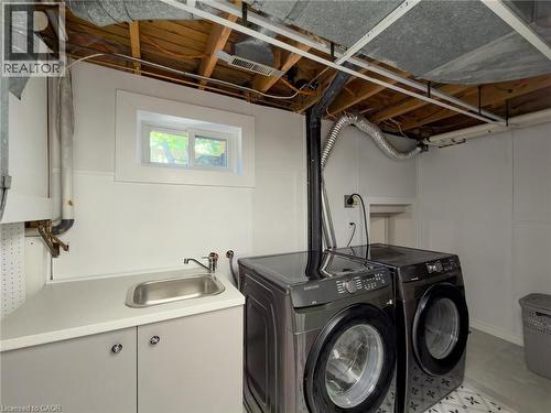 Dedicated laundry area featuring a utility sink, light gray base cabinetry, and a white countertop - 1324 Bodley Road, Mississauga, ON 
