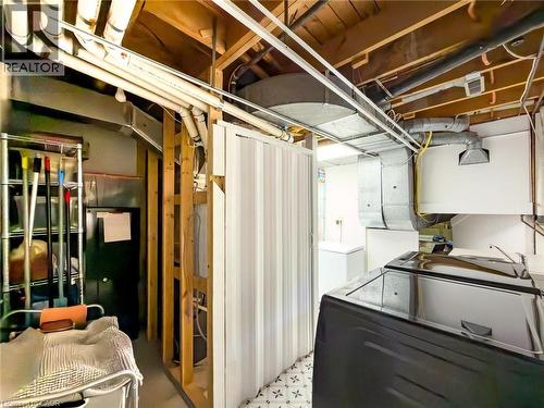 Laundry area featuring a black washing machine and a white dryer - 1324 Bodley Road, Mississauga, ON 