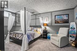 Carpeted room featuring a window with horizontal blinds, textured walls, and a paneled lower wall - 