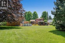 Expansive green lawn with mature perimeter trees - 
