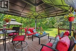 Spacious wood-finish deck with a large black gazebo featuring string lighting - 