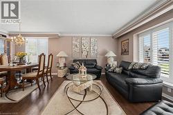 Open-concept living and dining area featuring wood-finish flooring - 