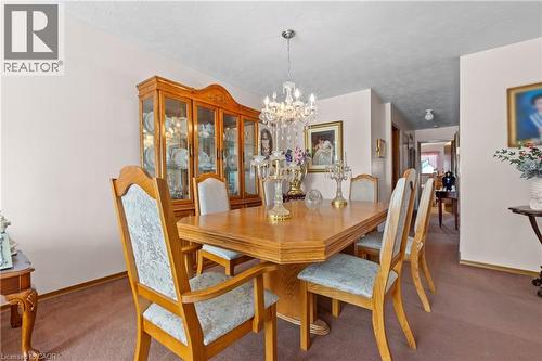 Dining area featuring a crystal chandelier, neutral wall paint. - 202 Ray Street N, Hamilton, ON - Indoor Photo Showing Dining Room