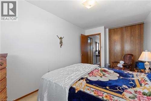Spacious bedroom featuring light-colored walls, wood-finish flooring, and a ceiling-mounted light fixture. - 202 Ray Street N, Hamilton, ON - Indoor Photo Showing Bedroom