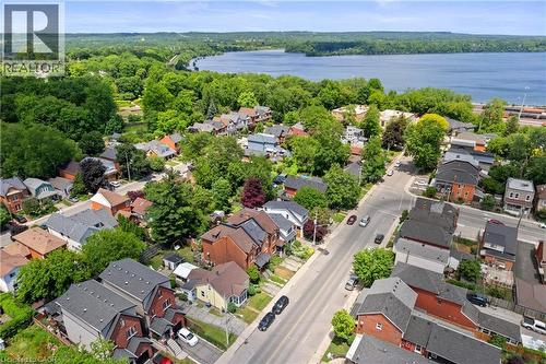 Residential properties featuring varied architectural styles and dark shingle roofing, set amidst mature green trees - 193 Locke Street N, Hamilton, ON - Outdoor With Body Of Water With View