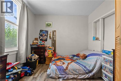 Room featuring wood-finish flooring, a window with curtains, and light-toned walls. - 193 Locke Street N, Hamilton, ON - Indoor Photo Showing Bedroom