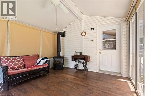 Enclosed sunroom featuring wood-finish flooring, a ceiling fan, and a built-in wood-burning stove. - 193 Locke Street N, Hamilton, ON - Indoor Photo Showing Other Room