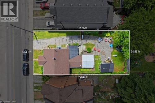 Aerial view showcasing the property with a brown shingled roof, extensive paved driveway, and established trees, with lot measurements. - 193 Locke Street N, Hamilton, ON - 