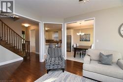 Hardwood flooring throughout the main living area, featuring a staircase with wood balusters and railing - 