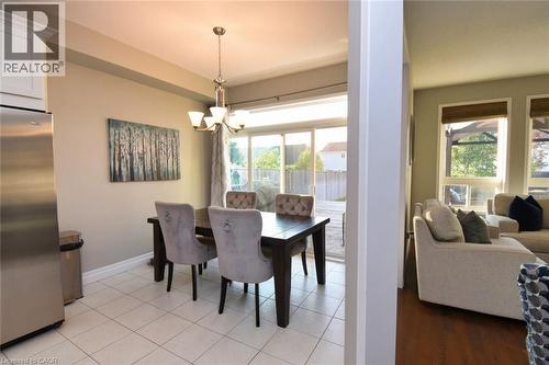 Dining area featuring neutral wall tones, square tile flooring, and a sliding glass door providing access to the exterior - 188 Hunter Way, Brantford, ON - Indoor Photo Showing Dining Room